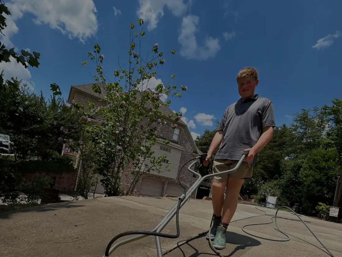 Cayman cleaning a driveway with professional pressure washing equipment